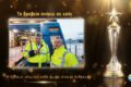 Two port workers in high-visibility jackets stand beside a blue Blue Star ferry at a dock, framed by a glowing panel with a gold trophy to the right.