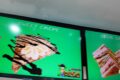 Bright green advertisement featuring a dessert crepe topped with whipped cream and chocolate drizzle; text reads 'SWEET CREPE' on the panel.