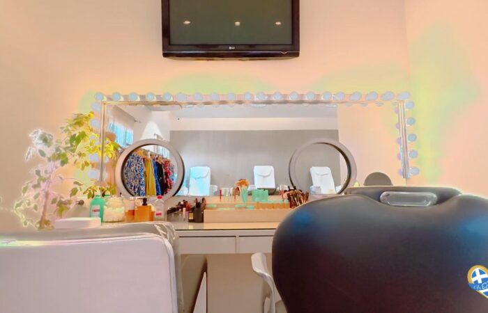 Nail salon station with twin circular mirrors, bright ring lights, and manicure supplies on the counter.