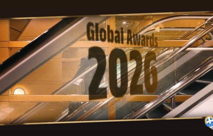 Escalators in a mall with gold-toned panels and glass, reflecting large dark numbers and partial text on the pane.